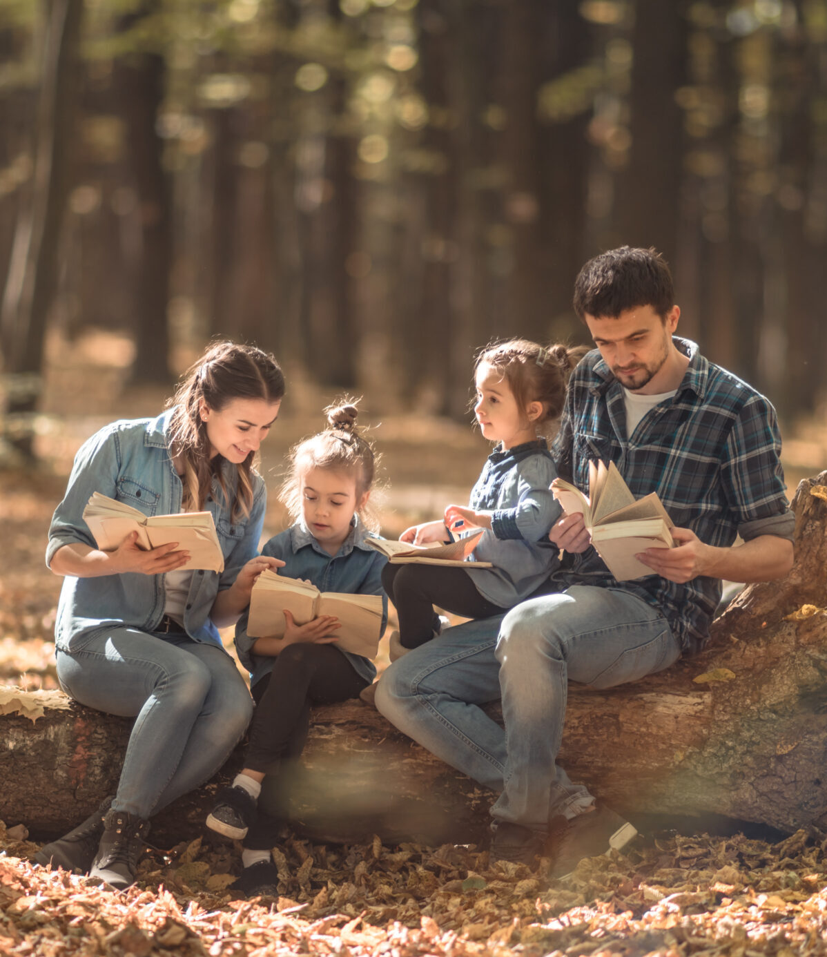 družina skupaj bere v gozdu